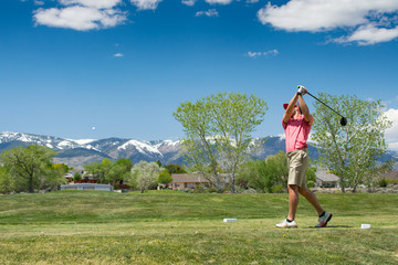 Male Golfer Hitting a Ball Off of the Tee Box In The Mountains of Lake Tahoe