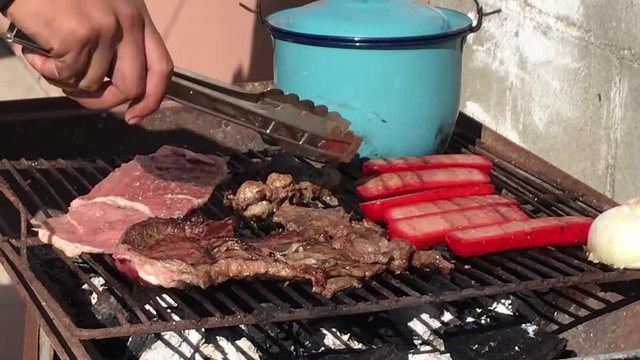 Traditional preparation of Mexican-style asado barbecue with carne asada and sausage on independence day in Baja California.