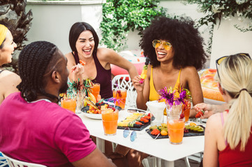 Group of happy multiracial friends talking and laughing having a conversation at lunch