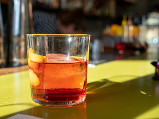 Negroni drink sitting on green bar counter top