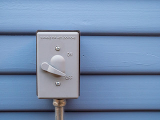 Outdoor heavy duty durable power switch attached to wall of home
