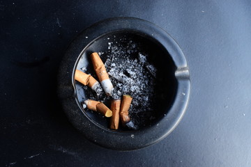 cigarette in an cycle black ashtray 