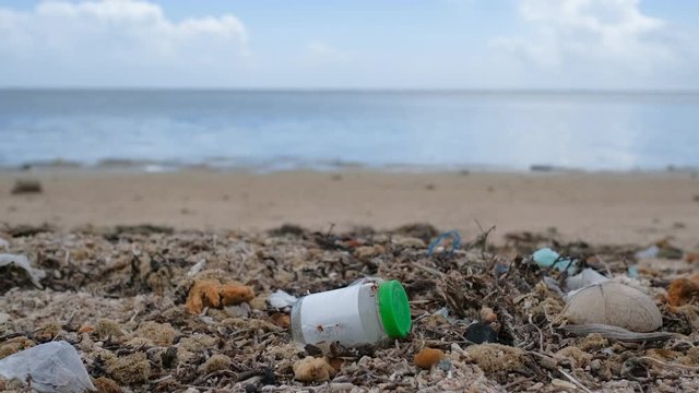 Trash, plastic, garbage, bottle, bag... environmental pollution on sandy beach. Royalty high-quality stock video footage trash, plastic bag, bottle on the beach. Waste that polluted ocean environment