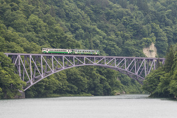 Fototapeta premium FUKUSHIMA, JAPAN - June 18 : The local train Tadami line and Tadami river on June 18 , 2017 in Fukushima , Japan. This train services in East Japan railway company's Tadami line.