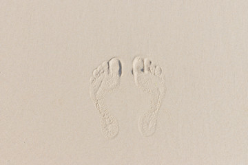 Summer holiday concept. Two footprint on the Sand.