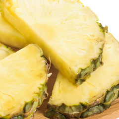 Fresh pineapple slices on brown chopping board.