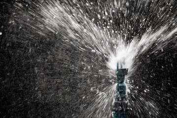 Obraz premium Close up view of sprinkler spraying water on blur background in garden.
