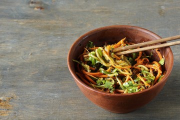 Asian cucumber and carrot salad with sesame, garlic, soy sauce and cilantro. top view. place for text. copy space.