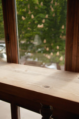 wooden empty table closeup and the window on background