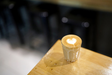 Hot Piccolo latte - A glass of coffee with milk and beautiful heart pattern latte art on wooden table background, Perfect for breakfast time.