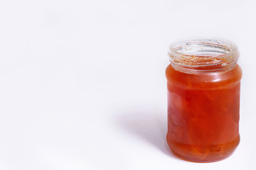 Glass jar of jam on a white background