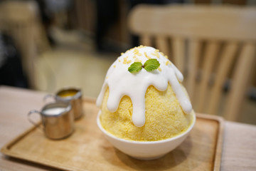 Mango kakigori (Bingsu) - Japanese shaved ice dessert flavor, stuffed with sticky rice and mango, topped with coconut fresh cream, Traditional summer dessert in Japan.