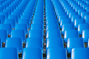 rows of empty blue seats in stadium. empty blue chairs.