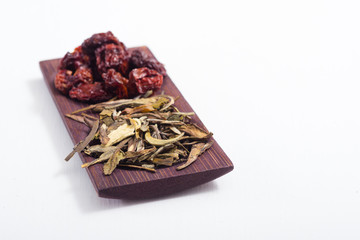dried fruits and spices on wooden tray, white table