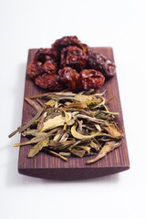 dried fruits and spices on wooden tray, white table