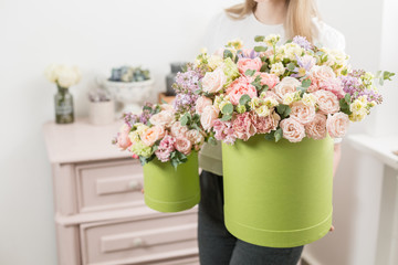Two Beautiful spring bouquets in head box. Arrangement with mix flowers. The concept of a flower shop, a small family business. Work florist. copy space