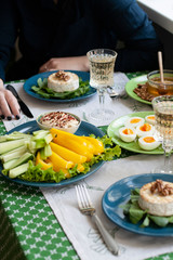 A gourmet lunch for two: grilled camembert, fresh vegetables, various appetizers and wine.