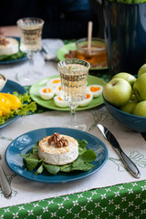 A gourmet lunch for two: grilled camembert, fresh fruits and vegetables, various appetizers and wine.