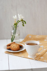 A tasty snack: a cup of tea and a plate of cookies.