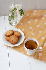 A tasty snack: a cup of tea and a plate of cookies.