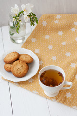 A tasty snack: a cup of tea and a plate of cookies.