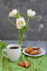 A tasty snack: a cup of coffee and a plate of cookies.