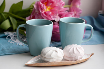 A break for two: cups of coffee and a plate of zefirs.