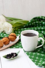 A tasty snack: a cup of tea and a plate of cookies.