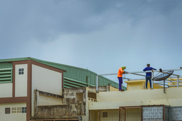 Worker welding the steel part for roof  before it is going to rain.