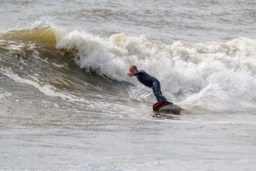 Middle Aged Man Surfing a wave