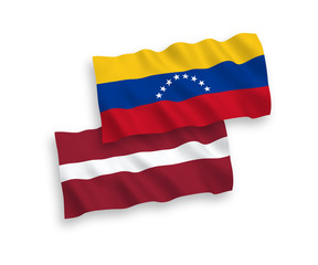 National vector fabric wave flags of Latvia and Venezuela isolated on white background. 1 to 2 proportion.