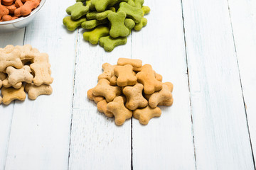 portion of dog food at tin bowl, brown and green heap of feed on floor