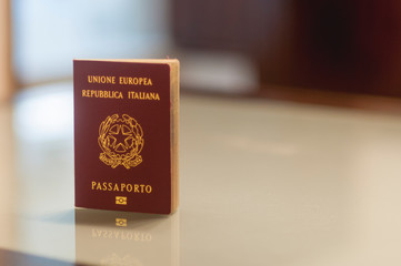 An italian passport on a glass table with reflection