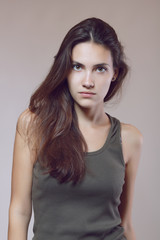 Fashion model. Young woman posing in studio. Beautiful caucasian girl over gray background, image toned.