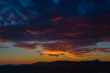 Fototapeta na wymiar Panoramic view of Mediterranean sea, sky with dramatic clouds at golden sunset in Palma de Mallorca, Spain.