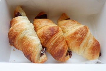 Three croissants containing chocolate in box