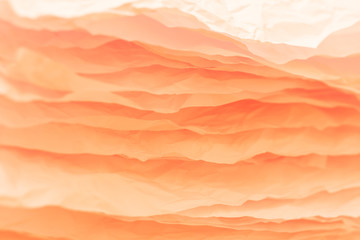 Closeup of orange crumpled paper layers stack. Abstract art background. Copy space.