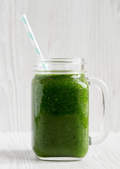 Spinach avocado banana  smoothie in a glass jar mug, side view. Close-up.