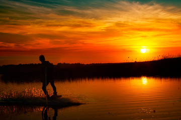 Wakeboarder making tricks on sunset