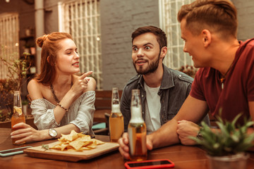 Beautiful woman and men sitting at the bar with beer