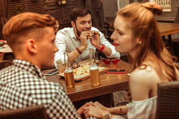 Dark-haired adult man looking enviously at his holding hands mates