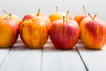 apple fruits in a row, white wooden table background