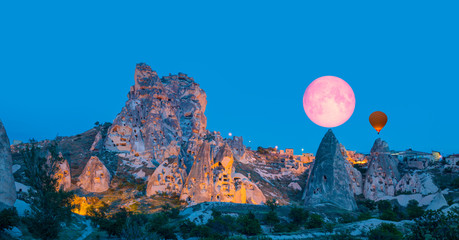 Amazing view of Uchisar castle in Cappadocia at twilight blue hour - Girls watching moonrise at the...