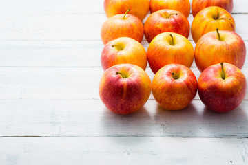 apple fruits in a row, white wooden table background
