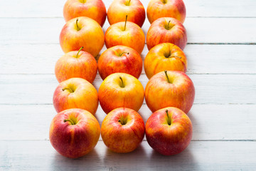 apple fruits in a row, white wooden table background