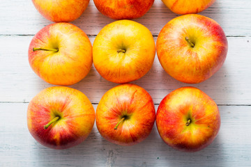 Naklejka na ściany i meble apple fruits in a row, white wooden table background