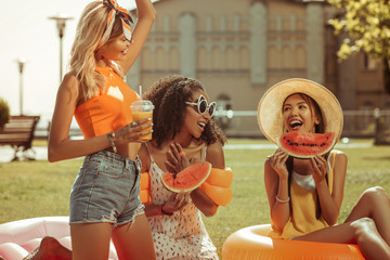 Energetic three girls having fun during a picnic outdoors