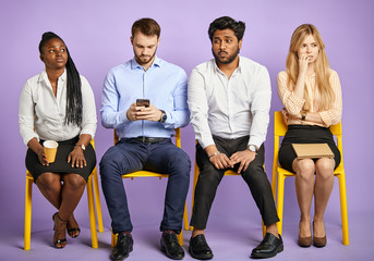 Young multinational applicants waiting for job interview feeling worried and stressed