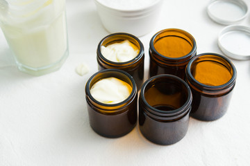 cosmetic lotion cream diy do it yourself ingredients creamer arrangement on white textile cloth top...