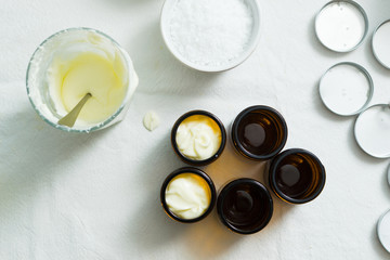 cosmetic lotion cream diy do it yourself ingredients creamer arrangement on white textile cloth top...
